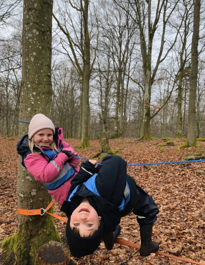 Två barn leker i skogen